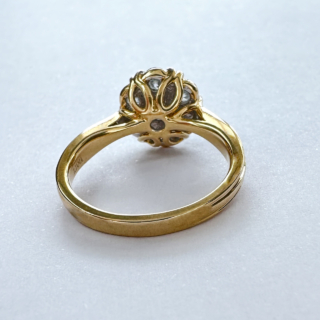A Vintage Designer Iliana Diamond Cluster Ring. Sparkling diamonds claw set, 7 bright modern brilliant cut diamonds in a 'flowerhead' style. The centre diamond 0.5ct with 6 surrounding modern brilliant cut diamonds, in all totalling 2.7ct weight of diamonds. The yellow gold shank is marked 18k & 750 with a London Hallmark plus makers mark Illiana. The beautiful gallery has a pierced swirling design. 