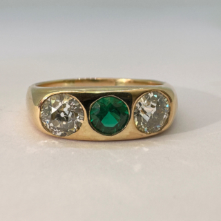 Antique Emerald and Diamond Three Stone Gypsy Ring set in 18ct Yellow Gold. The diamonds are transitional brilliant cut 1.4ct weight. The central emerald is Edwardian cut. The ring is currently UK size Q but can be resized. 