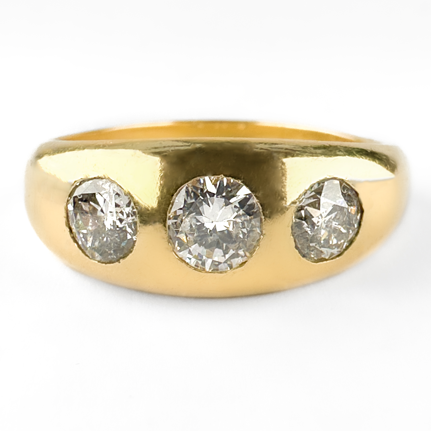 Edwardian 1.25ct 3 Diamond Gypsy Ring. A classic Edwardian three-stone diamond gypsy ring crafted in rich yellow 18ct gold. The ring is set with three transitional brilliant cut diamonds in a traditional flush gypsy setting, with a larger central stone flanked by two smaller diamonds. The central stone is 0.5cts with the total diamond weight being 1.25cts. Gypsy-set rings are highly fashionable desirable rings, prized for their smooth profile, durability and understated elegance. The softly domed gold mount showcases the diamonds beautifully while remaining comfortable for everyday wear. Combining timeless design with antique charm, this ring is equally suited as an alternative engagement ring, a meaningful anniversary gift or a treasured addition to an antique jewellery collection. The ring weighs 10.1g. Please contact us if you would like to know more about this lovely ring or visit us at Saddingtons Jewellery, Mayfair.