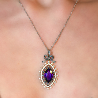 Exquisite Antique Marquise Amethyst Pearl & Diamond Pendant.A fabulous Edwardian pendant with a central oval rich colour amethyst surrounded by white enamel which has central gold decoration.The outer aspect of the pendant has rose cut diamonds and natural pearls surrounding.There is a rose diamond set bale and bow of which the pendant hangs.The chain is not included but can be sold separately.Please contact us if you would like further information on this stunning antique pendant.