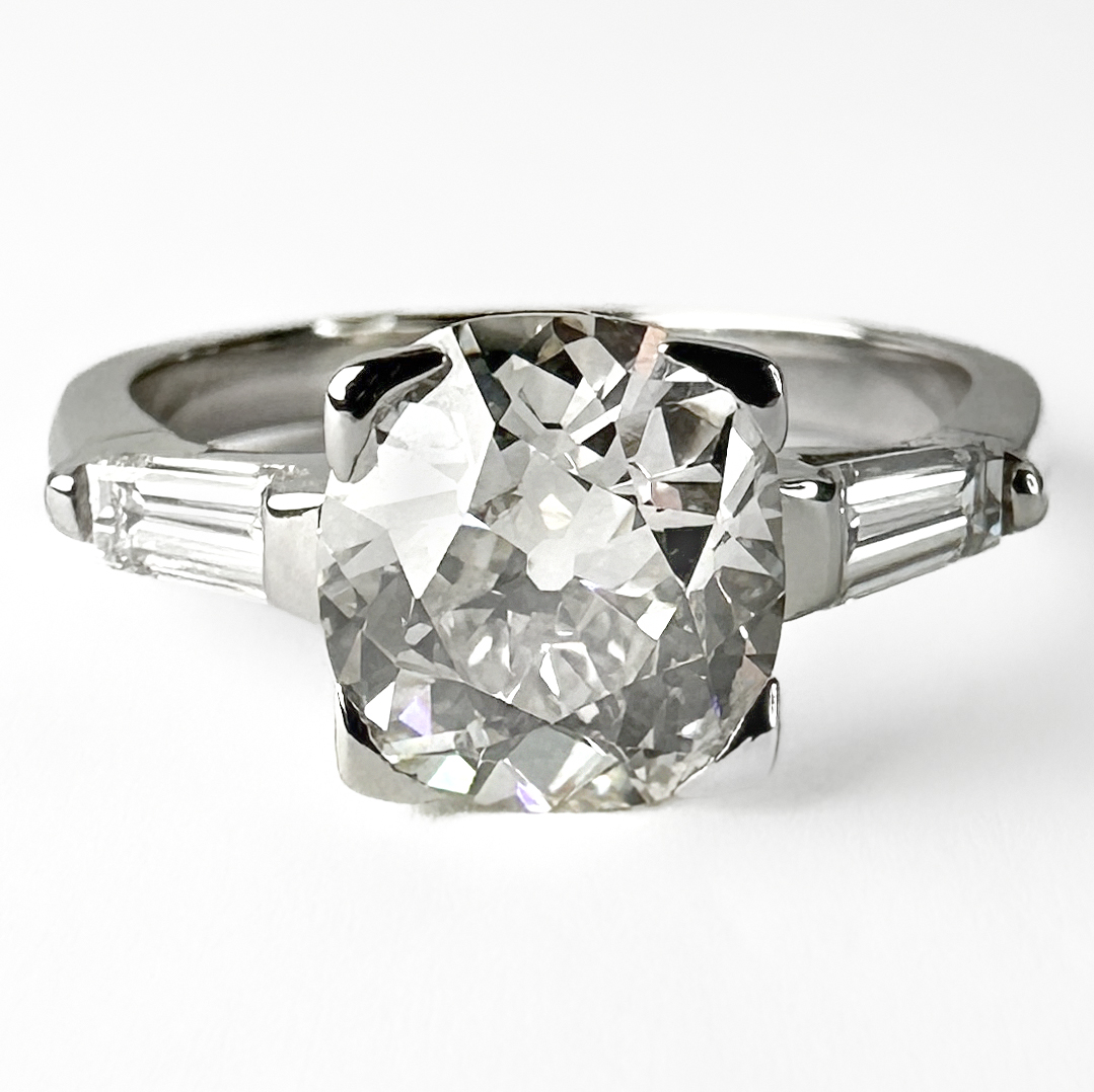 Exquisite Victorian Single Stone Diamond Ring. This stunning ring features a 2.23ct cushion cut victorian diamond as the center stone and two tapered baguette diamonds on either side weighing 0.1ct each. The stones are in a platinum contemporary mount and shank. The shank also features a 950 stamp. The diamond measures 8.4mm x 7.7mm. Please contact us if you would like to know more about this ring or visit us at Saddingtons Jewellery, Mayfair.