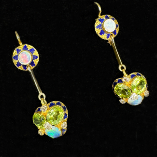 Stunning Antique Opal Peridot Diamond Enamel Drop Earrings set with Diamonds in a cluster setting. Truly unique and beautiful earrings. The drop from the ear 3.5cm with a shepards crook French wire safety hook in 15ct yellow gold. The top of the earring has intricate fancy enamel with vibrant colourful white opals. The drop has a vibrant and unusual cluster set with two peridots and a white opal. Four small old cut diamonds adding sparkle. Contact us for any further information. 