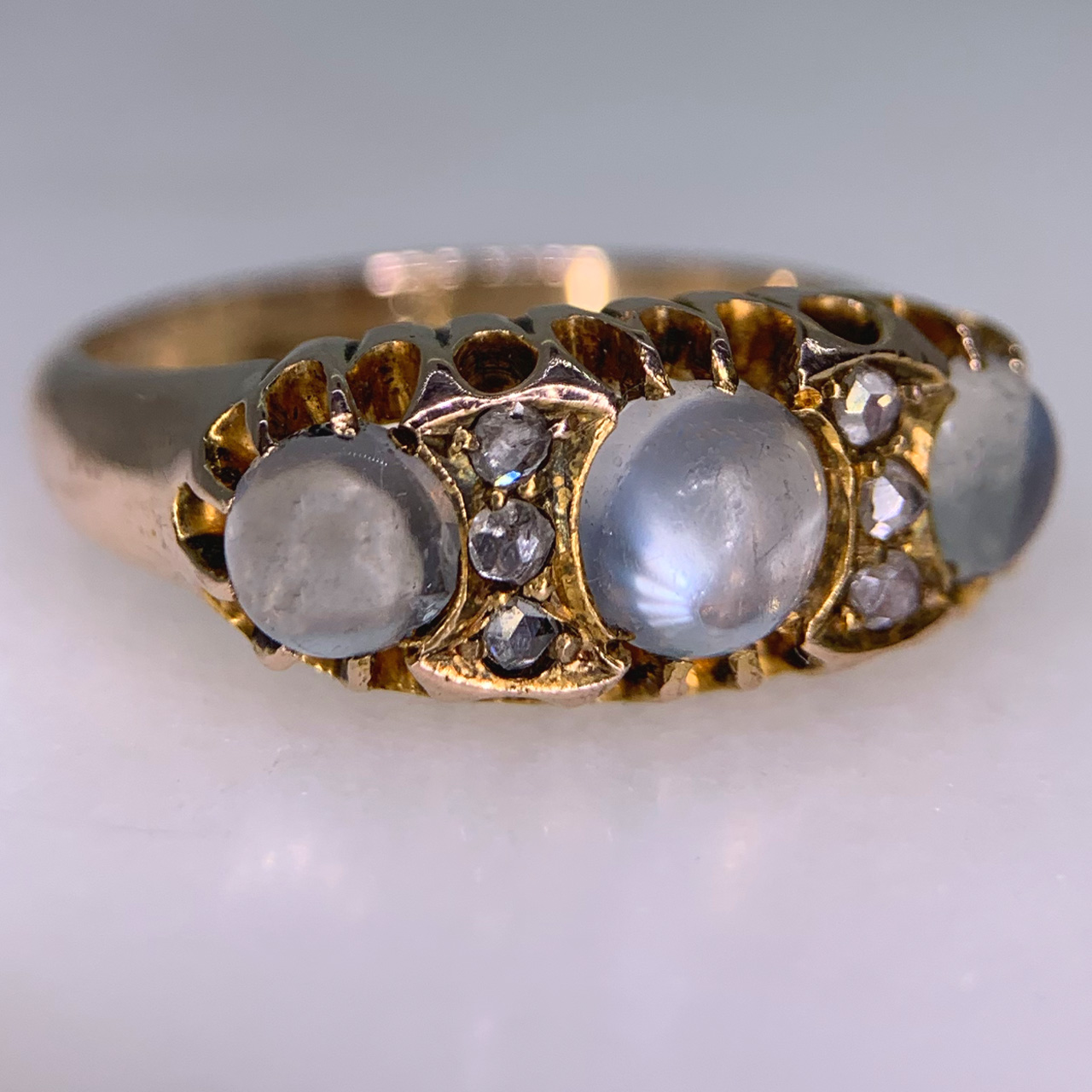 Stunning Edwardian Moonstone and Diamond Half Hoop in 18ct Rose Gold, Hallmarked Birmingham. This rare half hoop holds three cabochon Moonstone. The centre stone measures approximately 5 mm in diameter, the two side stones measure 3.8 mm in diameter, six rose cut diamonds with the diameter of 1.5 mm each separate the moonstones. All the stones are claw set in a decorative gallery 4 mm in depth, the shoulders run into a smooth polished half round shank, circa the Edwardian era. The ring is in excellent condition.