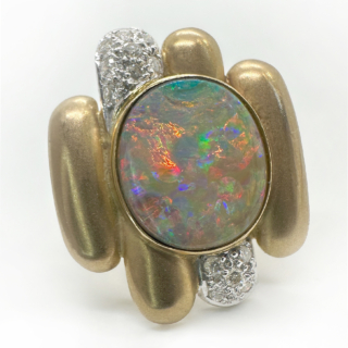 Vibrant Opal & Diamond Geometric Ring.A true one of a kind contemporary ring which has a large central opal showing magnificent flashes of colours of pink,blue,bright green and violet.The natural central oval opal measures 1.2cm x 1.4cm is rub-over set with rows of gold with 2 of the rows in white gold which has pave set diamonds.The shank of this striking ring is in yellow gold which has a brushed or frosted finish,14K inside with makers 'G&T'.The measurement of the head of the ring is 2.2cm x 2.4mm.This ring with unique style can be resized.Please contact us if you would like to know more about this ring.