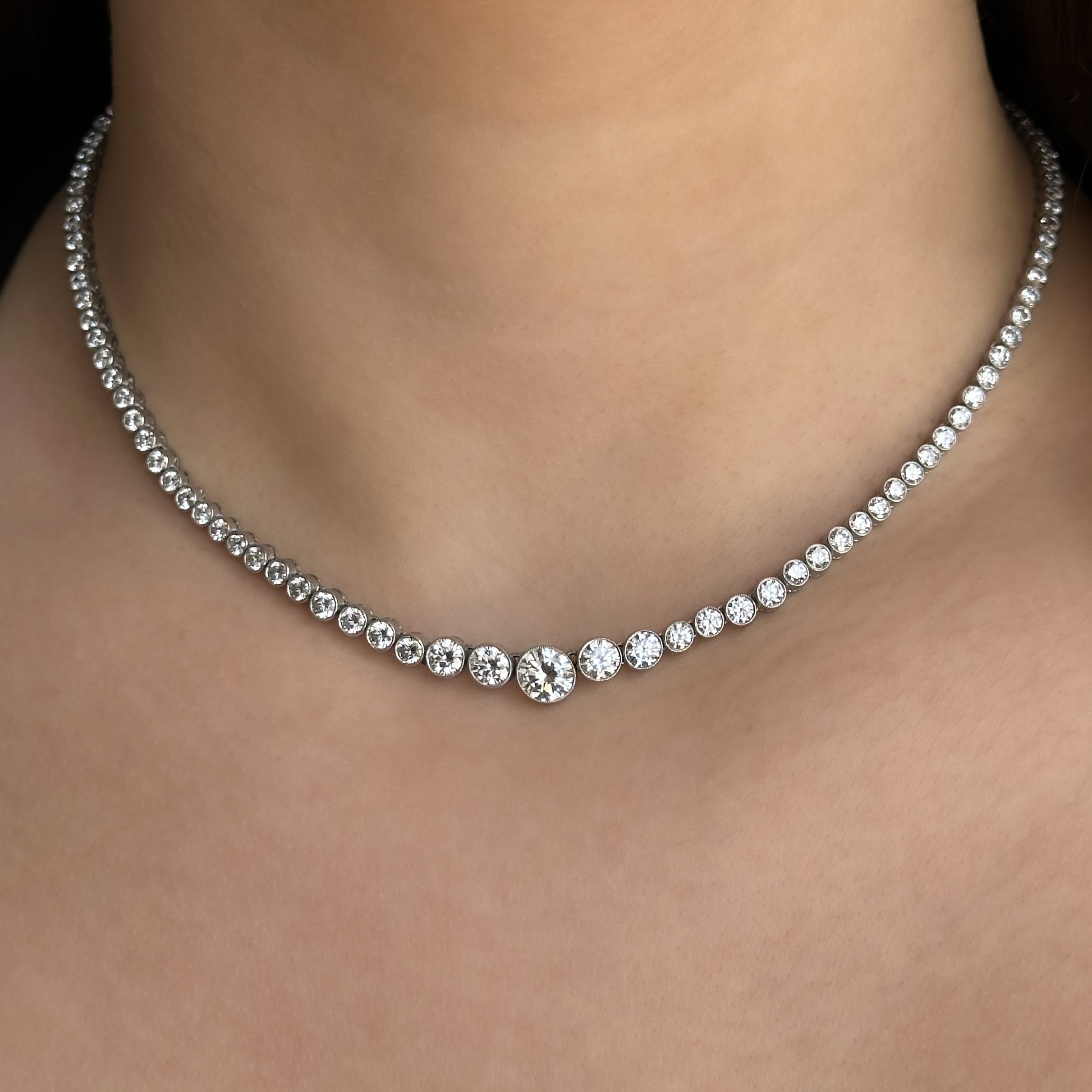 Stunning Graduated Riviera Diamond Necklace 12.5cts. This incredible contemporary diamond necklace features 121 round brilliant cut diamonds rub over set in platinum. The centre diamond is 0.98ct and the total diamond weight is 12.5cts. The diamonds are H-I in colour and VS1 clarity. It measures at 16.5 inches long and has a box clasp fastening with a safety catch. This is truly an incredible necklace that looks wonderful on. Please contact us if you would like to know more about this amazing necklace or visit us at Saddingtons Jewellery, Mayfair.
