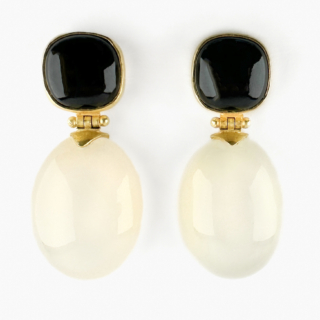 Chic Moonstone & Onyx Drop Earrings. An elegant and striking pair of 18ct gold drop earrings, designed with a sophisticated contrast of black onyx and luminous white moonstone. The one of a kind, craftsman made earrings are composed of polished cushion-shaped onyx tops, each suspending a smooth oval moonstone drop with a beautiful soft glow. The earrings feature a hinge link that gives gentle articulated movement of the moonstone drops, this adds softness and fluidity when worn. Chic, sculptural and exceptionally wearable, these vintage earrings transition effortlessly from daytime tailoring to evening wear. The gold on the earrings has a matte finish. The earrings are 32mm in length with the onyx measuring 11x11mm and the moonstone 20x15mm. Please contact us if you would like to know more about these lovely earrings or visit us at Saddingtons Jewellery, Mayfair.