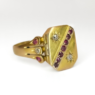 Rare and Desirable Antique Poison Ring Ruby & Diamonds.A stunning rectangular head of the ring,decorated with a diagonal line of pave set rubies with two graine set old cut diamonds on opposite sides of the ruby line.The head measures length1.3cm x 1cm width.There is a secret 'poison' compartment which is 0.3cm deep with a secure clasp and hinge in excellent condition.The door opens to reveal the 'secret' compartment.The compartment can be used for memorabilia or photos.The ring shoulders are carved with a central diamond with two rubies each side.An exceptional antique ring.Please contact us if you would like to know more about this ring.