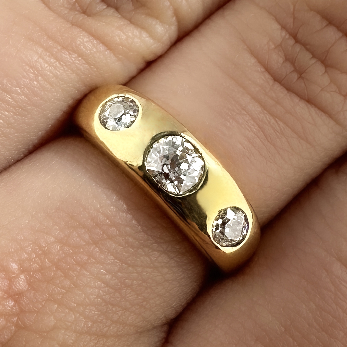 Stunning Edwardian 3 Stone Diamond Gypsy Ring. This beautiful ring features 3 sparkly transitional brilliant cut diamonds totalling 1ct. The diamonds are G-H in colour and VS2 clarity. The diamonds are rub over set in an 18ct yellow gold shank that has a 18ct stamp on the inside. The ring weighs 7.9 grams and sits very comfortably on the finger. Please contact us if you would like to know more about this beautiful ring or visit us at Saddingtons Jewellery, Mayfair.