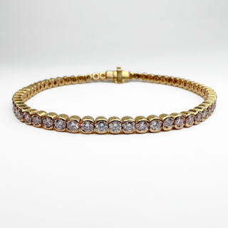 Vintage Natural Pink Diamond Line Bracelet. This pretty line bracelet features 62 soft pink diamonds rub over set in 18ct yellow gold. The bracelet measures 6.8 inches long and weighs 12.8 grams. The total diamond weight is 3.1cts and they are modern brilliant natural light pink in shade. The bracelet comes with a certificate. The bracelet has a box clasp and a hidden safety latch, on the fastening there is a 750 stamp as well as a makers mark. Please contact us if you would like to know more about this stunning bracelet or visit us at Saddingtons Jewellery, Mayfair.