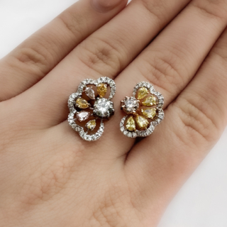 Gorgeous Yellow, Pink & White Diamond Flower Ring. This unusual vintage coloured diamond flower ring features buttery yellow, soft pink and white diamonds all claw set in 18ct white gold shank. The pink diamonds are set in rose gold and the yellow diamonds with yellow gold. The stunning open flower band design is very elegant and flattering on the finger. The weight of the ring is 8.1g. Stamped in the inside of the shank is an 18ct mark, a makers mark and also the weight of the diamonds. The white diamonds total 0.44cts and the coloured diamonds total to 2.60cts. The pink center diamond weighs 0.45cts and the opposite white diamond weighs 0.65cts. The diamonds are brilliant cuts and surrounding petals of each bloom are pear shaped. Each bloom is framed by pave white diamonds giving each flower a sparkling halo. Please contact us if you would like to know more about this ring or visit us at Saddingtons Jewellery, Mayfair.