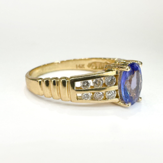 Striking Vintage Tanzanite & Diamond Cluster Ring.A beautiful 2ct oval faceted tanzanite central stone which is claw set with two rows of three bright sparkling brilliant cut diamonds.The gems are set in 14ct yellow gold and is UK size K but can be resized preserving the mark.Please contact us if you would like to know more about this ring.
