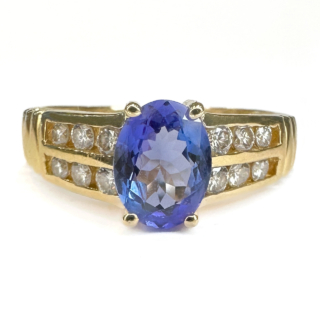 Striking Vintage Tanzanite & Diamond Cluster Ring.A beautiful 2ct oval faceted tanzanite central stone which is claw set with two rows of three bright sparkling brilliant cut diamonds.The gems are set in 14ct yellow gold and is UK size K but can be resized preserving the mark.Please contact us if you would like to know more about this ring.