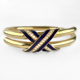 Lovely Victorian Gold Enamel & Pearl Bangle. A beautifully elegant antique Victorian 15ct gold blue enamel and seed pearl hinged bangle, internally engraved and dated. This refined mid-Victorian bangle is designed with a graceful crossover motif, decorated with rich royal blue enamel and delicate rows of graduating seed pearls. The smooth tubular gold construction gives the piece an understated sophistication, while the vivid enamelwork provides striking contrast against the warm tones of the gold. The bangle opens via a discreet concealed hinge and integrated clasp typical of fine Victorian jewellery craftsmanship. Jewellery of this period often carried symbolic meaning, with blue enamel traditionally associated with loyalty and devotion, and seed pearls representing purity and affection. The engraving inside reads 'S C E C and Ruthie' '24th August 1854'. The inscription adds a wonderful sense of romance and authenticity, preserving the personal history of the piece. Elegant and highly wearable, the bangle sits beautifully on the wrist and transitions effortlessly from daywear to evening styling. It may be worn alone as a refined antique statement piece or layered with contemporary gold jewellery for a more modern aesthetic. The piece weighs 17.5g. Please contact us if you would like to know more about these stunning earrings or visit us at Saddingtons Jewellery, Mayfair.