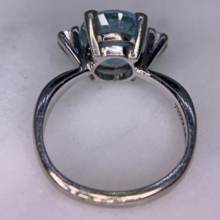 Exquisite Outsized Aquamarine and Diamond Trilogy Ring, in stamped 18ct White Gold. The centre aquamarine measures 3.8carats, enclosed by two diamonds. All the stones are claw set and measure 16 mm x 12 mm together, with a basket depth of 7 mm. The ring has a stylish flat-sided court shank, with a sort of square outer appearance. Excellent ring.