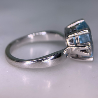 Exquisite Outsized Aquamarine and Diamond Trilogy Ring, in stamped 18ct White Gold. The centre aquamarine measures 3.8carats, enclosed by two diamonds. All the stones are claw set and measure 16 mm x 12 mm together, with a basket depth of 7 mm. The ring has a stylish flat-sided court shank, with a sort of square outer appearance. Excellent ring.