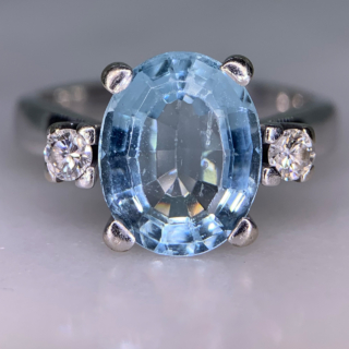 Exquisite Outsized Aquamarine and Diamond Trilogy Ring, in stamped 18ct White Gold. The centre aquamarine measures 3.8carats, enclosed by two diamonds. All the stones are claw set and measure 16 mm x 12 mm together, with a basket depth of 7 mm. The ring has a stylish flat-sided court shank, with a sort of square outer appearance. Excellent ring.