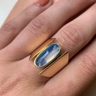 Unusual Brutalist Geometric Solitaire Moonstone Ring, stamped 750 (18ct) Yellow Gold. The exquisite ring has a 16 mm x 7 mm statement oval moonstone. The up-finger design of the ring shows an oval moonstone, bezel set, in yellow gold, with two geometric wide shoulders that taper to the back of the shank. The head measures approximately 21 mm x 11 mm, and tapers to 5 mm at the back of the ring. The ring is in absolutely immaculate condition and is a clear statement piece, great worn alone or in addition to other up-finger rings. 