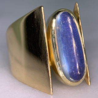 Unusual Brutalist Geometric Solitaire Moonstone Ring, stamped 750 (18ct) Yellow Gold. The exquisite ring has a 16 mm x 7 mm statement oval moonstone. The up-finger design of the ring shows an oval moonstone, bezel set, in yellow gold, with two geometric wide shoulders that taper to the back of the shank. The head measures approximately 21 mm x 11 mm, and tapers to 5 mm at the back of the ring. The ring is in absolutely immaculate condition and is a clear statement piece, great worn alone or in addition to other up-finger rings. 