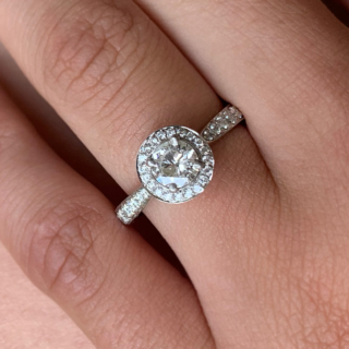 Incredible Diamond Halo Cluster Ring in 950 Platinum. The exquisite halo ring has a 0.63carat centre diamond, claw set with diamond halo. The head of the ring measures 9 mm in diameter with 12 diamond embellished shoulders. The ring has a flat sided-court shank, polished. All the stones are claw set. The ring is in absolutely immaculate condition.