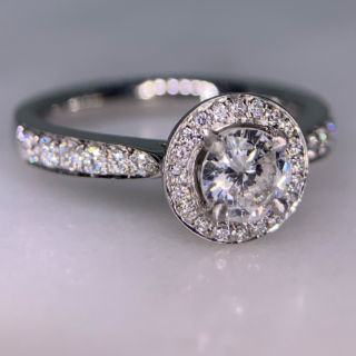 Incredible Diamond Halo Cluster Ring in 950 Platinum. The exquisite halo ring has a 0.63carat centre diamond, claw set with diamond halo. The head of the ring measures 9 mm in diameter with 12 diamond embellished shoulders. The ring has a flat sided-court shank, polished. All the stones are claw set. The ring is in absolutely immaculate condition.