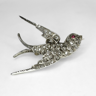 Beautiful Victorian Antique Diamond Swallow Brooch.Circa 1880. Pave set rose cut diamonds over the swallow in flight. The diamonds are set in silver, typical of the era. The swallow has a cabochon ruby. The back of the swallow brooch is 15ct yellow gold with a robust 15ct yellow gold lever and catch securing pin. The swallow measures 3.2 x 2.6 cm. This brooch is boxed, please contact us if you would like to know more about this brooch or visit us at Saddingtons Jewellery, Mayfair.