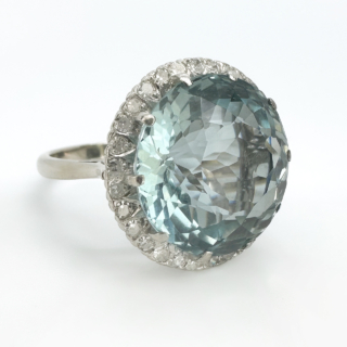 Statement Large Aquamarine Diamond Circular Cluster Ring.The central faceted 13.3ct  Aquamarine has a beautiful sea blue green hue and is surrounded by bright brilliant cut diamonds.A stones are natural and claw set in a 18ct white gold marked in the shank.The head of the ring measures 1.8cm diameter with a depth of 0.8mm off the finger.The ring can be resized,please contact us if you would like more information on this ring.