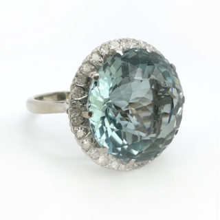 Statement Large Aquamarine Diamond Circular Cluster Ring.The central faceted 13.3ct  Aquamarine has a beautiful sea blue green hue and is surrounded by bright brilliant cut diamonds.A stones are natural and claw set in a 18ct white gold marked in the shank.The head of the ring measures 1.8cm diameter with a depth of 0.8mm off the finger.The ring can be resized,please contact us if you would like more information on this ring.