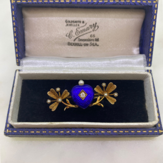 Much desired Victorian Blue Enamelled Heart and Clover Brooch, in 15  carat tested yellow gold.  Rich dark blue enamel heart with central old cut diamond and single pearl crown.  The heart is nestled between two pearl set clover leaves.  The clovers have chased leaf detail with seed pearl accents.  The whole brooch measures approximately 38mm x 16mm, all stones are claw set.  The rear of the brooch has a 15carat gold pin and C clasp with no safety catch.   The brooch would have possibly been a gift given from the heart to bring good luck to the recipient.  In immaculate condition, showing a small surface scratch to the bottom of the blue heart  in keeping with the age of the brooch.