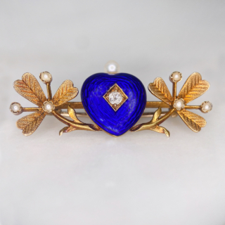 Much desired Victorian Blue Enamelled Heart and Clover Brooch, in 15  carat tested yellow gold.  Rich dark blue enamel heart with central old cut diamond and single pearl crown.  The heart is nestled between two pearl set clover leaves.  The clovers have chased leaf detail with seed pearl accents.  The whole brooch measures approximately 38mm x 16mm, all stones are claw set.  The rear of the brooch has a 15carat gold pin and C clasp with no safety catch.   The brooch would have possibly been a gift given from the heart to bring good luck to the recipient.  In immaculate condition, showing a small surface scratch to the bottom of the blue heart  in keeping with the age of the brooch.