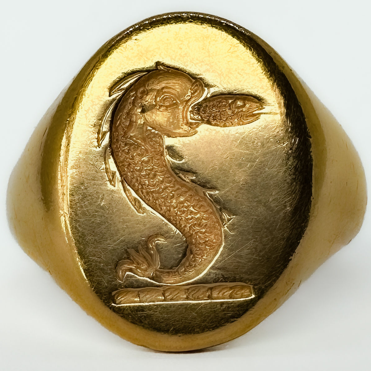 A Striking And Substantial Vintage Nautical Crest Intaglio Signet Ring. In 18ct yellow gold dating to the 1980s, and distinguished by a finely carved intaglio crest of likely nautical inspiration. Crafted in rich yellow gold and weighing an impressive 15 grams, this is a piece that carries immediate presence on the hand — a true statement signet ring in the traditional sense. The intaglio carving, cut in reverse as a seal, evokes the long-standing heritage of signet rings as markers of identity, authority, and lineage.The crest itself suggests maritime or naval associations, lending the ring a sense of story and potential provenance beyond its already strong aesthetic appeal. Whether originally commissioned as a personal seal or later acquired for its symbolism. Ideal for a collector of unusual signet rings, or a buyer seeking a piece with individuality and depth, this ring sits comfortably between traditional gentleman’s jewellery and contemporary statement wear.A rare opportunity to acquire a heavily weighted, intaglio-carved gold signet ring with both decorative and symbolic appeal.