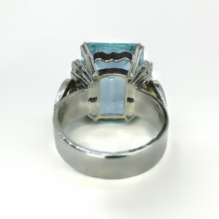 A Statement 21ct Aquamarine & Diamond Cocktail Ring.A fantastic vintage 1970's large aquamarine set with 4 beautiful full cut diamonds each side highlighting the central stone.The shank is polished 18ct white gold 9 marked inside the shank.The central aquamarine and diamonds are claw set.Typical of the era,the head of the ring sits just under 1cm from the finger,the head of the ring measures 1.8cm length x 1.8 width which includes the diamond rows on the side.The ring has a wide gold band 0.5cm wide.A beautiful statement on the finger,this ring can be resized.Please contact us if you would like to know more about this ring.