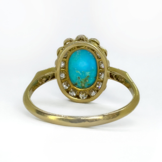 An Oval Antique Turquoise & Diamond Cluster Ring.The ring shank is in 18ct yellow gold with the diamonds set in platinum.A vibrant natural blue turquoise central oval stone surrounded by beautiful bright transitional cut diamonds additionally there are x2 diamonds set on each side of the shoulders of the ring, a total diamond content 1ct.The top of the ring measures 15 x 12mm.The ring is set low and sits comfortable on the finger.This ring can be resized,please contact us if you would like to know more about this ring.
