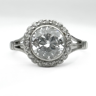 Stunning Edwardian Diamond Cluster Ring 1.2ct. This gorgeous ring has a 1.2ct transitional brilliant cut diamond in a rub over setting in a splayed shoulder platinum shank. The center stone is surrounded by small edwardian cut diamonds also in rub over settings. This ring is very nice and can be described as an original halo style ring. The ring can be resized. Please contact us if you would like to know more about this ring or visit us at Saddingtons Jewellery, Mayfair.