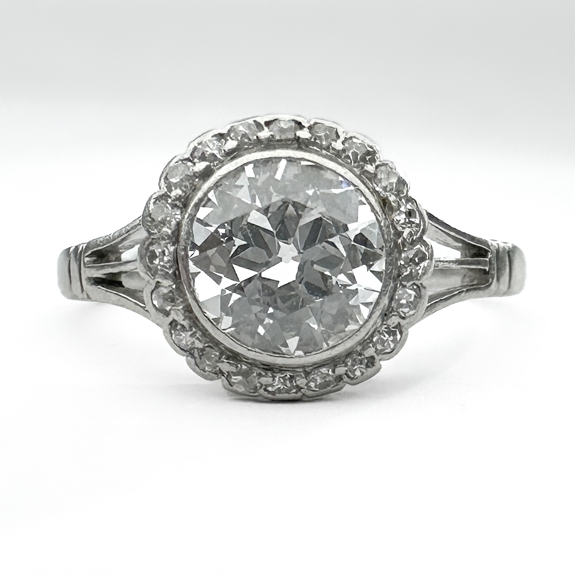Stunning Edwardian Diamond Cluster Ring 1.2ct. This gorgeous ring has a 1.2ct transitional brilliant cut diamond in a rub over setting in a splayed shoulder platinum shank. The center stone is surrounded by small edwardian cut diamonds also in rub over settings. This ring is very nice and can be described as an original halo style ring. The ring can be resized. Please contact us if you would like to know more about this ring or visit us at Saddingtons Jewellery, Mayfair.