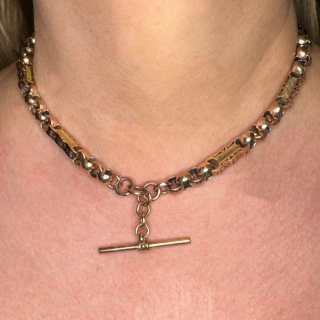 Unusual and Exquisite Rose Gold Fancy Albert Neckchain. The chain has circular faceted links with curvy oblong links with a pierced curves and stars set to the front and sides of these links. The chain measures 15.5 inches with a T-Bar drop of 1 inch. The chain has dog clip fastening and the chain has makers name and hallmarks to the dog clip and T-Bar.