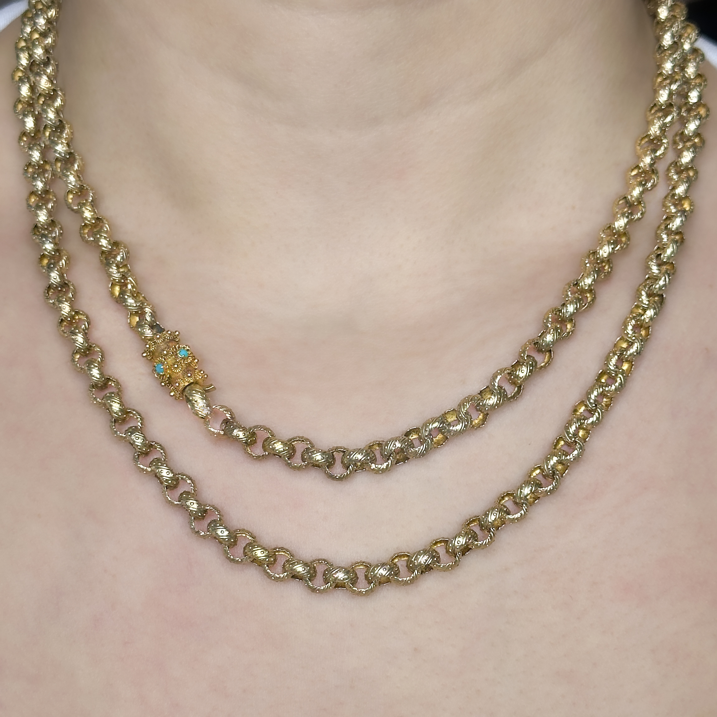 A stunning Late Georgian Fancy Link Guard Chain. This exquisite cannetille fancy belcher links in 15ct yellow gold measures 38 inches and has a barrel catch with small turquoise set in the barrel.