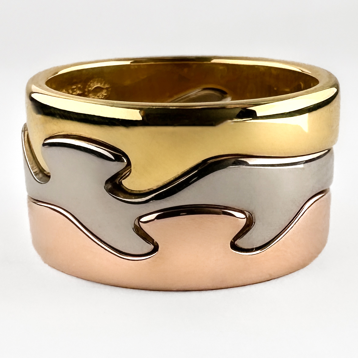 Georg Jensen Fusion 3 Ring Stack. This Iconic stack has 3 18ct gold tricolour bands that seamlessly interlock. The organic wave like bands 'fuse' together to create a contemporary and interesting design. These rings were designed by Nina Koppel who was commissioned by Georg Jensen. All 3 bands feature full Georg Jensen hallmarks including a Denmark stamp, N K stamp and 750 gold stamp. These yellow, rose and white gold rings can be worn together or separately. Please contact us if you would like to know more about this beautiful ring stack or visit us at Saddingtons Jewellery, Mayfair.