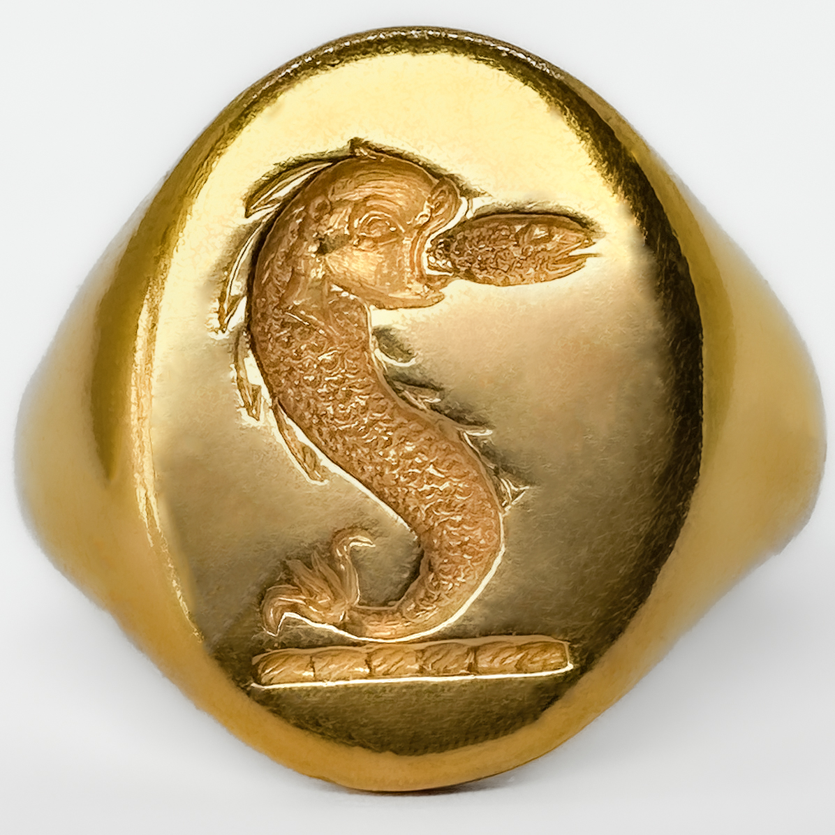 A Striking And Substantial Vintage Nautical Crest Intaglio Signet Ring. In 18ct yellow gold dating to the 1980s, and distinguished by a finely carved intaglio crest of likely nautical inspiration. Crafted in rich yellow gold and weighing an impressive 15 grams, this is a piece that carries immediate presence on the hand — a true statement signet ring in the traditional sense. The intaglio carving, cut in reverse as a seal, evokes the long-standing heritage of signet rings as markers of identity, authority, and lineage. The crest itself suggests maritime or naval associations, lending the ring a sense of story and potential provenance beyond its already strong aesthetic appeal. Whether originally commissioned as a personal seal or later acquired for its symbolism. Ideal for a collector of unusual signet rings, or a buyer seeking a piece with individuality and depth, this ring sits comfortably between traditional gentleman’s jewellery and contemporary statement wear. A rare opportunity to acquire a heavily weighted, intaglio-carved gold signet ring with both decorative and symbolic appeal. Please contact us if you would like to know more about this wonderful ring or visit us at Saddingtons Jewellery, Mayfair.