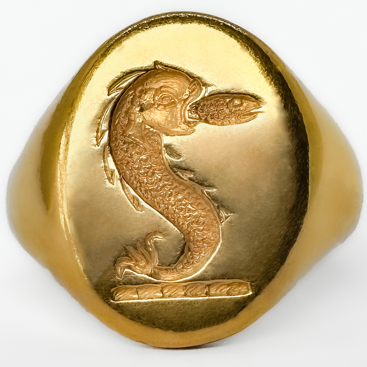 A Striking And Substantial Vintage Nautical Crest Intaglio Signet Ring. In 18ct yellow gold dating to the 1980s, and distinguished by a finely carved intaglio crest of likely nautical inspiration. Crafted in rich yellow gold and weighing an impressive 15 grams, this is a piece that carries immediate presence on the hand — a true statement signet ring in the traditional sense. The intaglio carving, cut in reverse as a seal, evokes the long-standing heritage of signet rings as markers of identity, authority, and lineage. The crest itself suggests maritime or naval associations, lending the ring a sense of story and potential provenance beyond its already strong aesthetic appeal. Whether originally commissioned as a personal seal or later acquired for its symbolism. Ideal for a collector of unusual signet rings, or a buyer seeking a piece with individuality and depth, this ring sits comfortably between traditional gentleman’s jewellery and contemporary statement wear. A rare opportunity to acquire a heavily weighted, intaglio-carved gold signet ring with both decorative and symbolic appeal. Please contact us if you would like to know more about this wonderful ring or visit us at Saddingtons Jewellery, Mayfair.