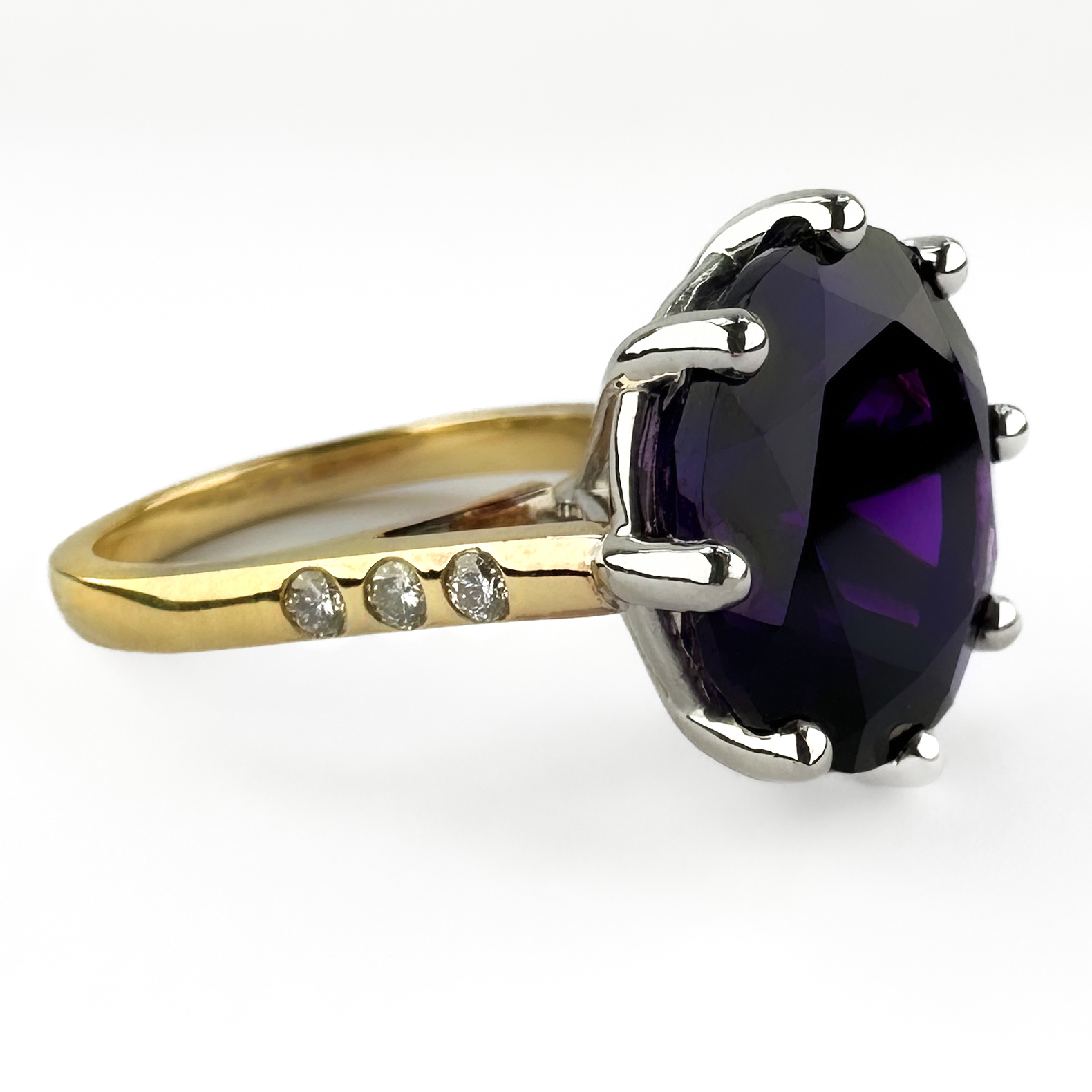 Large Vintage Amethyst & Diamond Ring. A striking vintage dress ring set with a large richly coloured round brilliant-cut amethyst in an elegant claw setting, complemented by 3 diamonds set on each shoulder in 9ct yellow gold. The elevated gallery gives the ring a dramatic and sculptural presence on the hand, allowing the deep violet amethyst to catch the light beautifully from every angle. Hallmarked for Birmingham with 375 gold marks and maker’s initials “KJ”. A bold and glamorous statement ring. Please contact us if you would like to know more about this lovely ring or visit us at Saddingtons Jewellery, Mayfair.