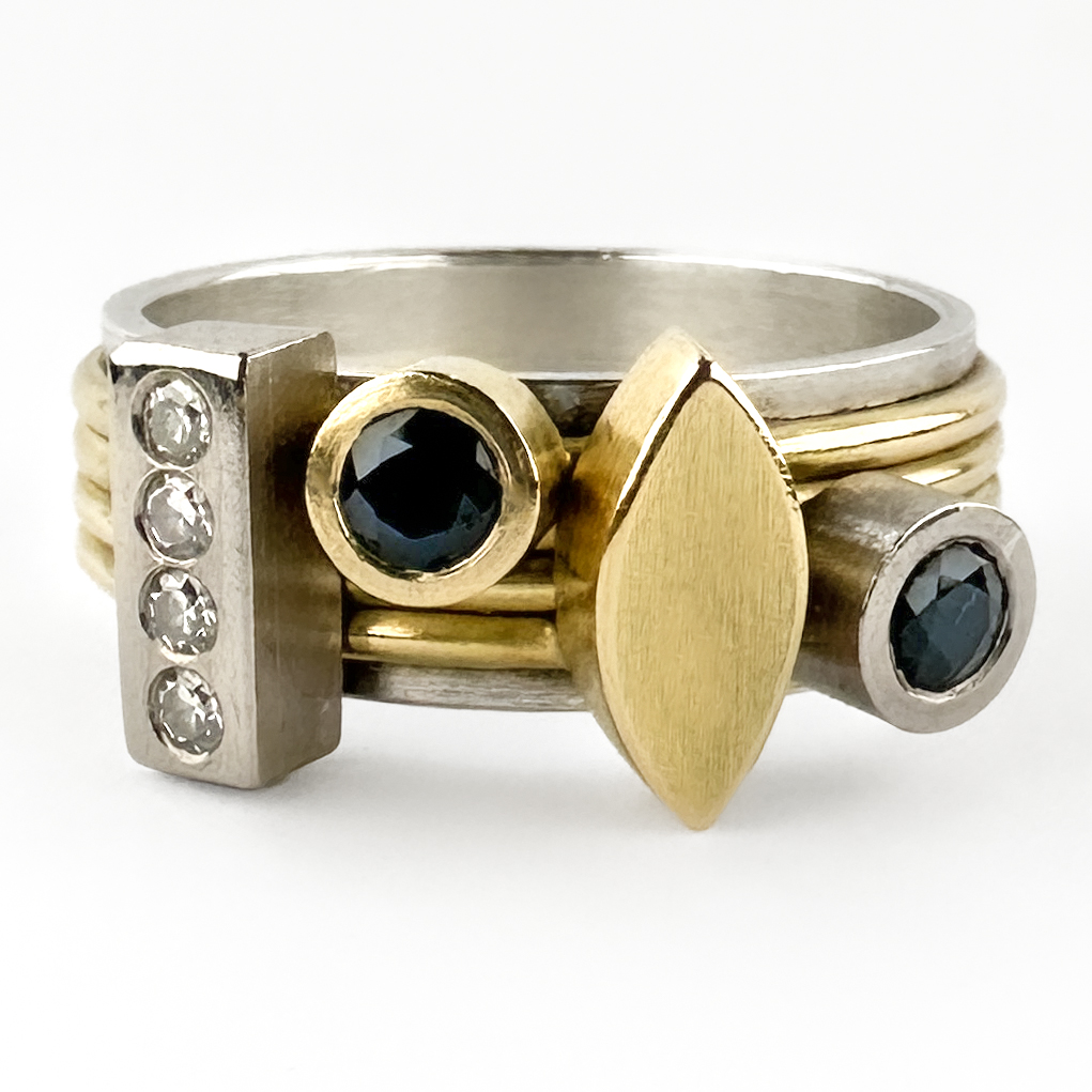 Modernist Sapphire & Diamond Spinner Ring. A striking modernist ring featuring articulated moving bands set with deep blue sapphires and brilliant-cut diamonds. The inner band is silver and the bands are crafted in yellow gold. With an architectural, sculptural feel, the design allows the individual gold bands to rotate independently, creating subtle movement and interaction when worn. The bold geometric styling gives the piece a distinctly contemporary aesthetic while retaining the craftsmanship of a hand-finished studio jewellery. An unusual and highly wearable statement ring. The piece is by an unsigned designer and is excellently made with a very high level of craftsmanship. Please contact us if you would like to know more about this amazing ring or visit us at Saddingtons Jewellery, Mayfair.