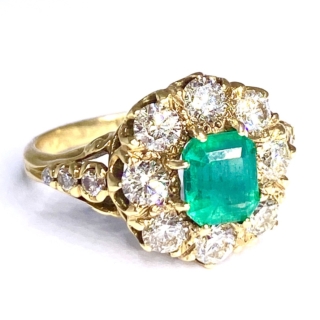 18ct yellow gold emerald and brilliant cut diamond ring. with diamond embellished shoulders.