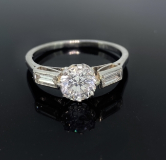 Vintage Diamond Solitaire Ring, set with a central diamond of 1.05ct diamond weight.  ColourE and VS2, G.I.A. Diamond Certificated.  The ring has diamond baguette shoulders set in a platinum mount.  The ring is size P1/2 but can be resized free of charge,  The solitaire ring is of exceptional quality and in excellent condition. An outstanding diamond ring,