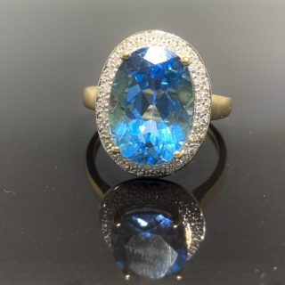 Blue Topaz Cocktail Ring 9ct gold, 6.5 carat blue topaz central stone surrounded by a halo of small sparkly diamonds