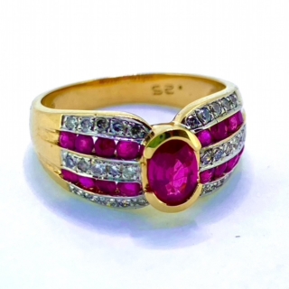 Ruby and Diamond Stylised Ring, Hallmarked London 375 (for 9ct gold). The head of the ring holds one central faceted ruby measuring 7mm X 4mm, surrounded by 16 channel set rubies and 35 grain set diamonds. 