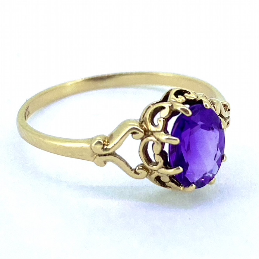 Solitaire Amethyst Gold, hallmarked 9ct. The ring head is a faceted vibrant purple Amethyst, claw set. The mount is embellished with meaningful heart detail and split shank shoulder.