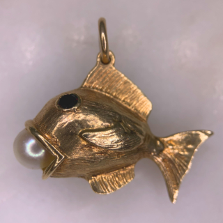 Characterful Vintage Garnet and Pearl in Mouth Fish Charm in 9ct Rose Gold, Hallmarked London, 1965. This wonderful charm has two deep garnet eyes, bezel set, measuring approximately 3 mm in diameter. The fish holds a fresh water pearl 6 mm in diameter in an open mouth. The fish is designed with intricate fin and scale chased detail. The total fish measures 31 mm x 22 mm (excluding the 7 mm loop). The charm is in excellent condition and a perfect quirky addition to any charm bracelet or necklace.