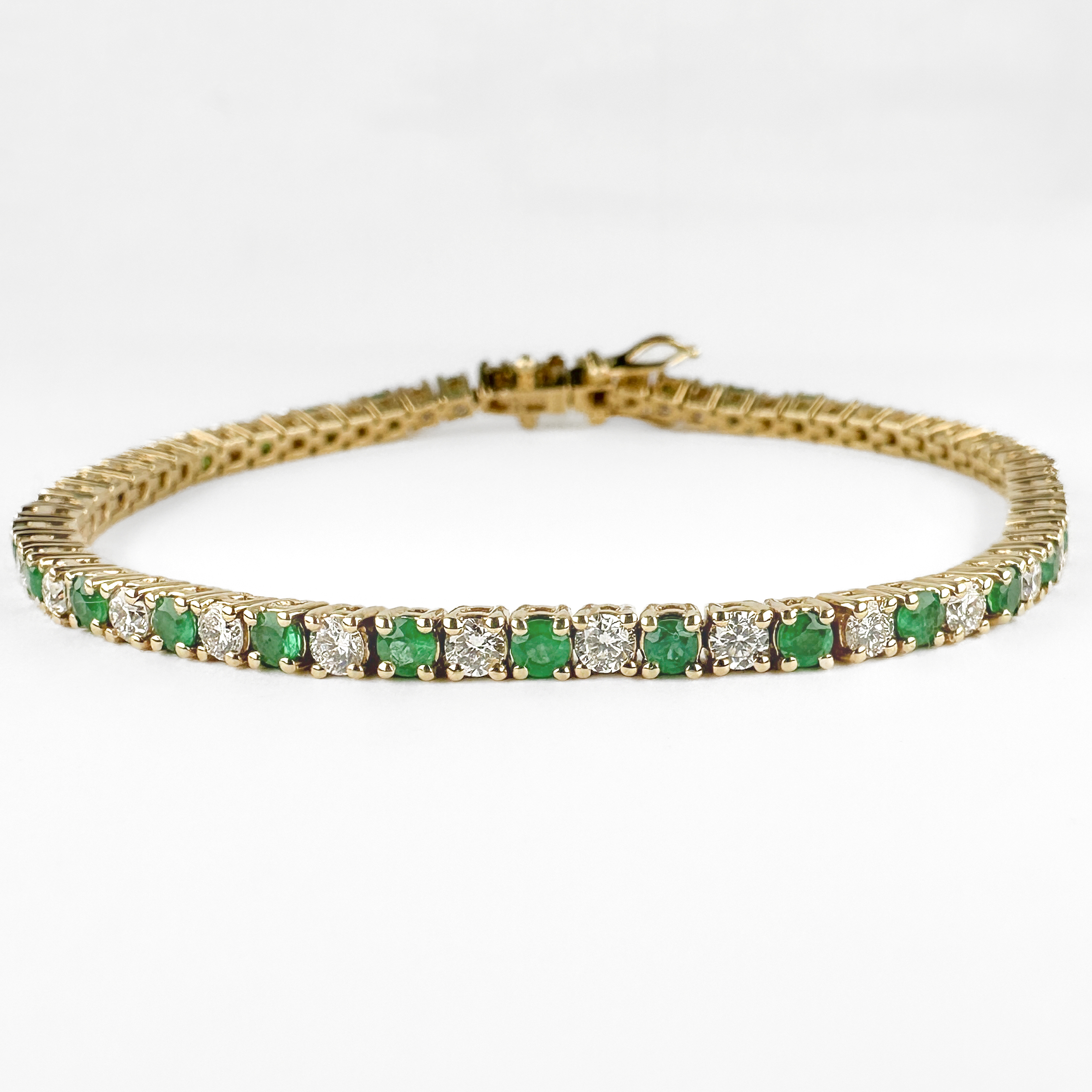 Vintage Emerald & Diamond Tennis Bracelet. This stunning bracelet has 31 diamonds 0.06ct diamonds totalling to 1.86cts and 32 emeralds totalling to 1.5cts. All the stones are claw set in yellow gold. The bracelet measures 7 inches long and looks very elegant on the wrist. The bracelet is fastened by a box clasp and safety catch which features an 18ct stamp and Italian makersmark. Please contact us if you would like to know more about this gorgeous bracelet or visit us at Saddingtons Jewellery, Mayfair.