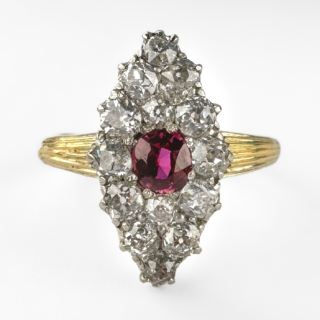 Elegant Diamond & Burma Ruby Marquise Ring. The ring features 14 twinkling old cut diamonds around a central red/pink old cut burma ruby. The shank is 18ct yellow gold with an 18ct mark. All the gems are claw set. The head of the ring measures at 1.8cm x 1cm and the ring sits low on the finger. This ring can be resized. Please contact us if you would like to know more about this stunning ring or visit us at Saddingtons Jewellery, Mayfair. 