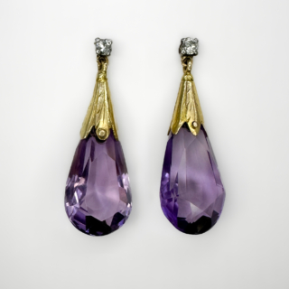 1940's fabulous Large Amethyst Drop Earrings. Pear drop faceted amethysts set with 18ct yellow textured gold with a small brilliant cut diamond stud in 18ct white gold. The earrings drop 3cm from the lobe piercing, the earrings have a beautiful sway adding to the glistening sparkle. The earrings have a stud fixing with a securing 18ct yellow gold butterfly fixing. Please contact us if you would like to know more about the earrings or visit us at Saddingtons Jewellery, Mayfair.